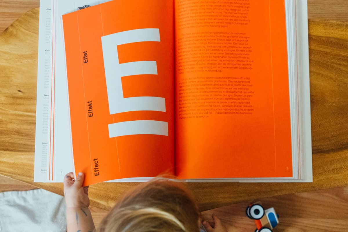 Child reading an orange book