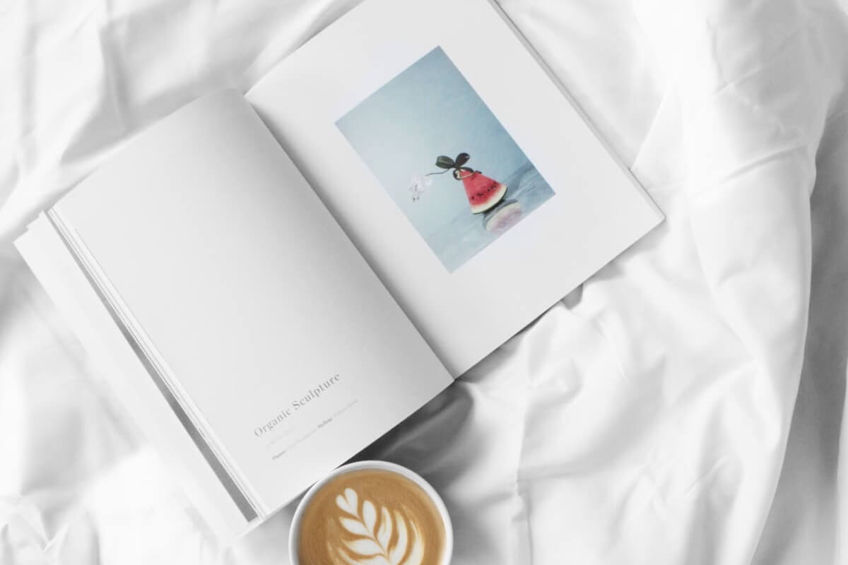 book and coffee on white sheets